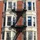 HMO Key Requirements and Considerations - multi-occupancy building exterior with fire escape stairs for safety compliance